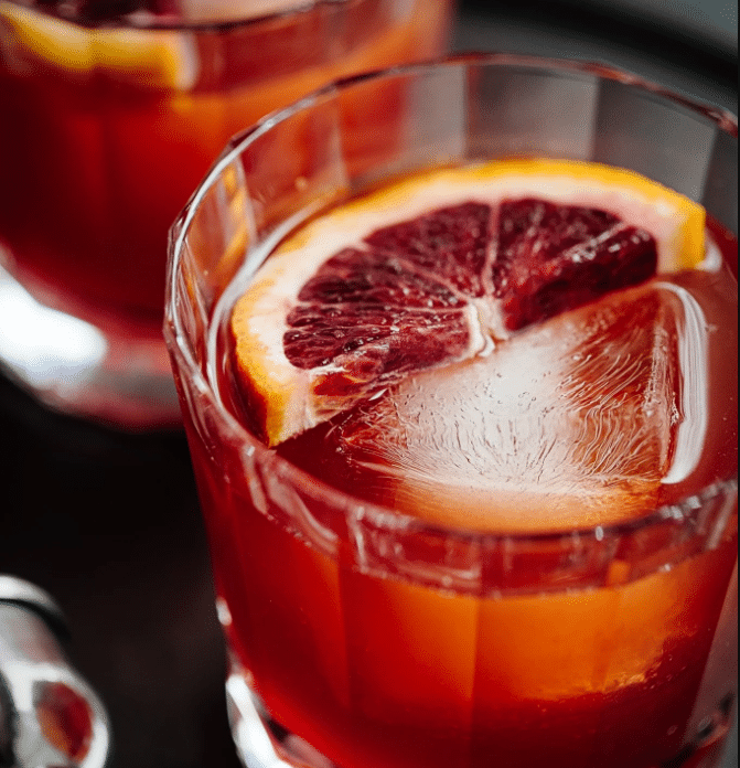 Xalapa Punch is served in a whiskey glass with a slice of blood orange and ice