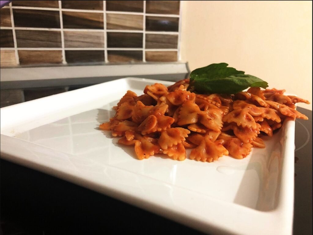 Pasta with JarKitchen special pasta sauce. Sauce is red in color and garnished with 2 basil leaves on top. It tastes great with Hard Rock and Roll Sauce.